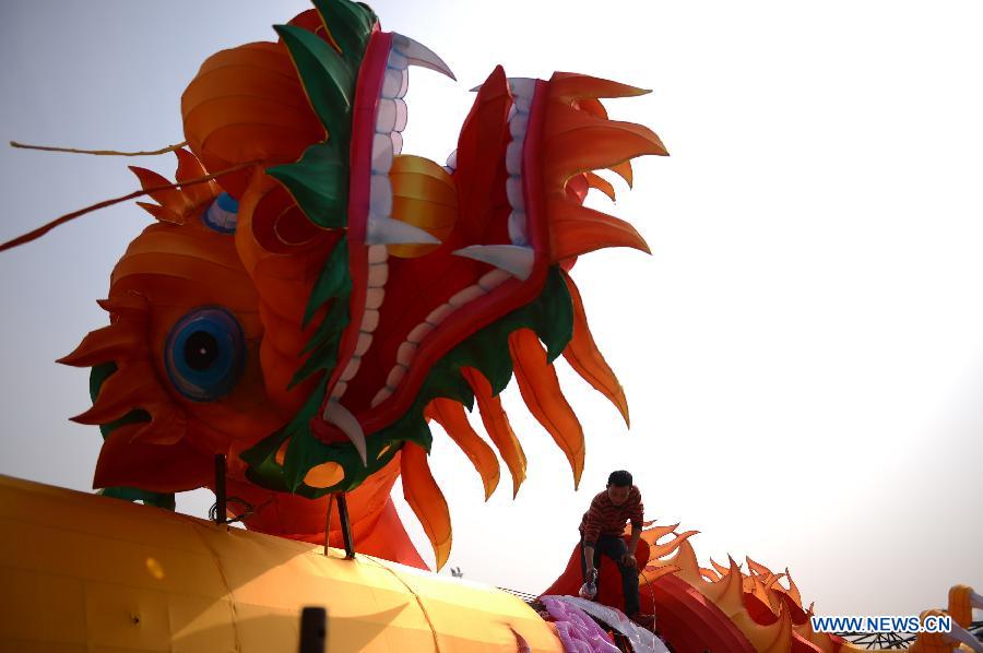 A man works on a lantern in the shape of Chinese dragon on the street in Nanchang, capital of east China's Jiangxi Province, Jan. 28, 2013. Lanterns designed in Zigong of southwest China's Sichuan Province will meet with the residents here during the upcoming Spring Festival holidays. (Xinhua/Zhou Mi) 