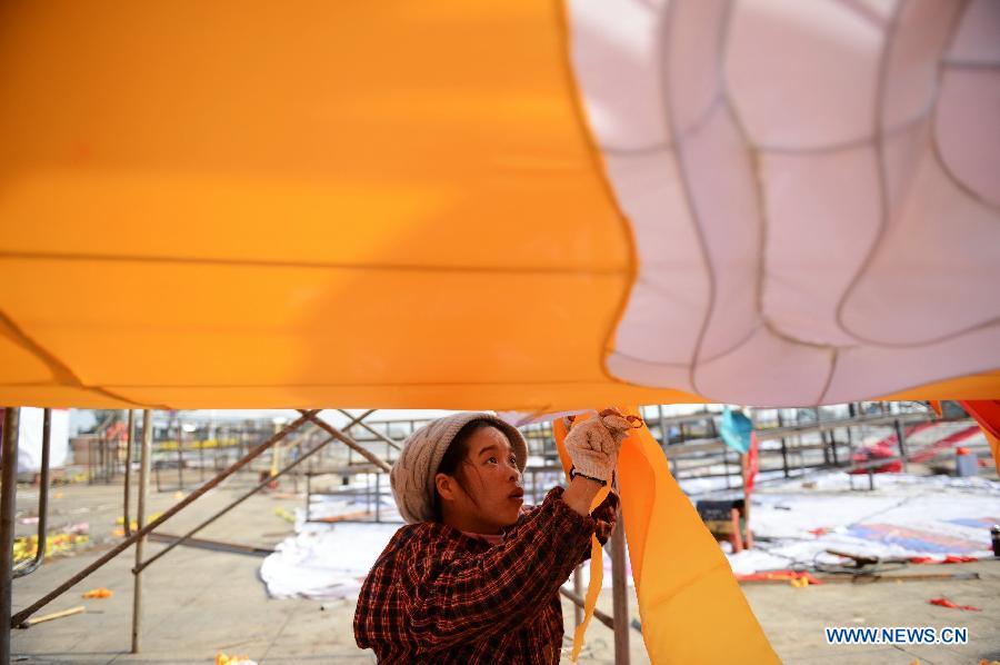 A woman works on a lantern on the street in Nanchang, capital of east China's Jiangxi Province, Jan. 28, 2013. Lanterns designed in Zigong of southwest China's Sichuan Province will meet with the residents here during the upcoming Spring Festival holidays. (Xinhua/Zhou Mi) 