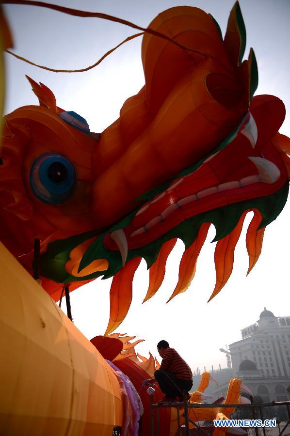 A man works on a lantern in the shape of Chinese dragon on the street in Nanchang, capital of east China's Jiangxi Province, Jan. 28, 2013. Lanterns designed in Zigong of southwest China's Sichuan Province will meet with the residents here during the upcoming Spring Festival holidays. (Xinhua/Zhou Mi) 