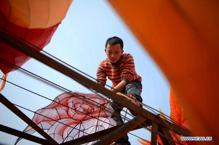 A man works on a lantern in the shape of Chinese dragon on the street in Nanchang, capital of east China's Jiangxi Province, Jan. 28, 2013. Lanterns designed in Zigong of southwest China's Sichuan Province will meet with the residents here during the upcoming Spring Festival holidays. (Xinhua/Zhou Mi) 