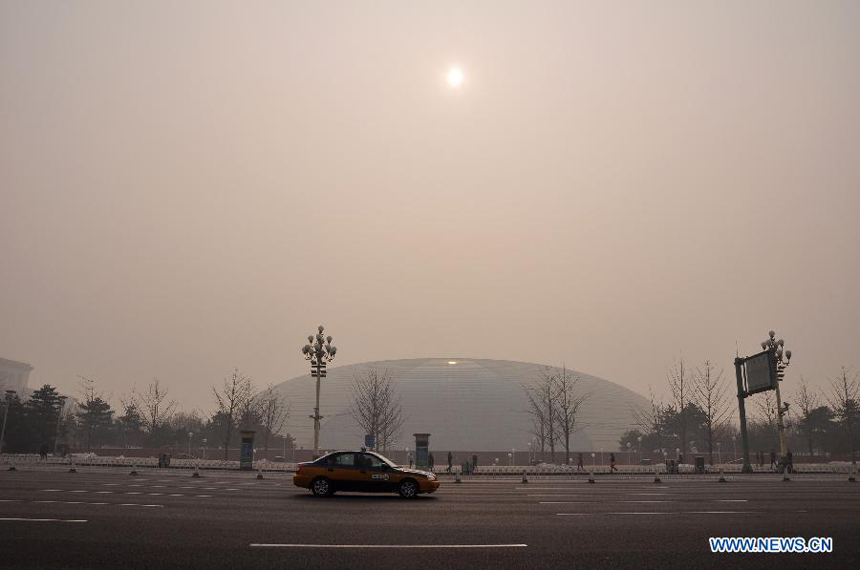 A taxi travels in the street shrouded by fog in Beijing, capital of China, Jan. 28, 2013. The National Meteorological Center (NMC) issued a blue-coded alert on Jan. 27 as foggy weather forecast for the coming two days will cut visibility and worsen air pollution in some central and eastern Chinese cities.