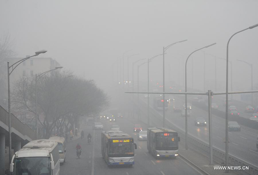 Vehicles move slowly on a fog-shrouded road in Beijing, capital of China, Jan. 29, 2013. The National Meteorological Center (NMC) issued a blue-coded alert early Tuesday as foggy weather forecast for the coming hours will cut visibility and worsen air pollution in some central and eastern Chinese cities. 