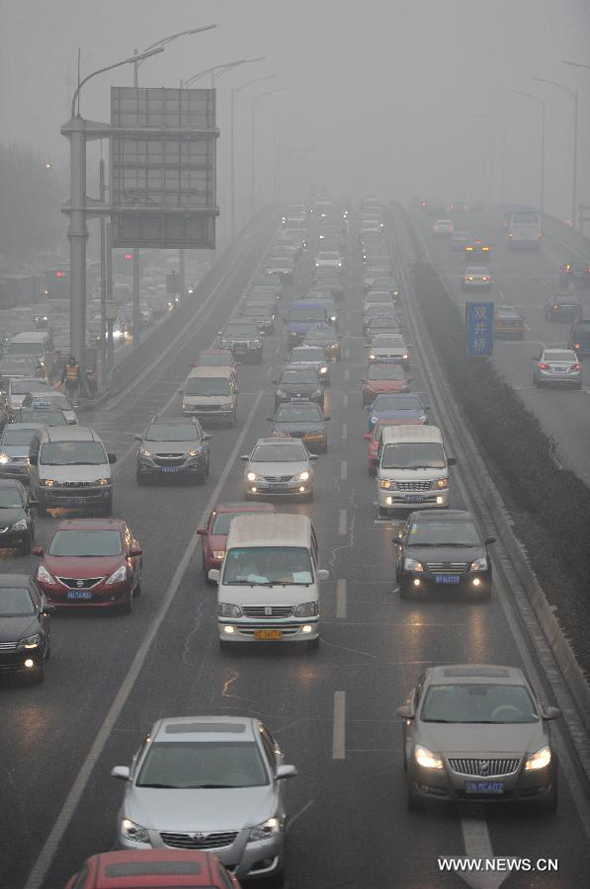 Vehicles move slowly on a fog-shrouded road in Beijing, capital of China, Jan. 29, 2013. The National Meteorological Center (NMC) issued a blue-coded alert early Tuesday as foggy weather forecast for the coming hours will cut visibility and worsen air pollution in some central and eastern Chinese cities.