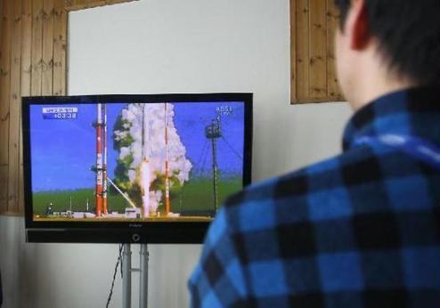 A staff member watches the live broadcast of Naro launching in News Center of Winter special Olympics in Pyongchang, South Korea, on Jan. 30, 2013. South Korea launched its Korea Space Launch Vehicle-1 (KSVL-1), also known as Naro, at 4 p.m. local time from the Naro Space Center, located 480 kilometers south of Seoul, on Wednesday.