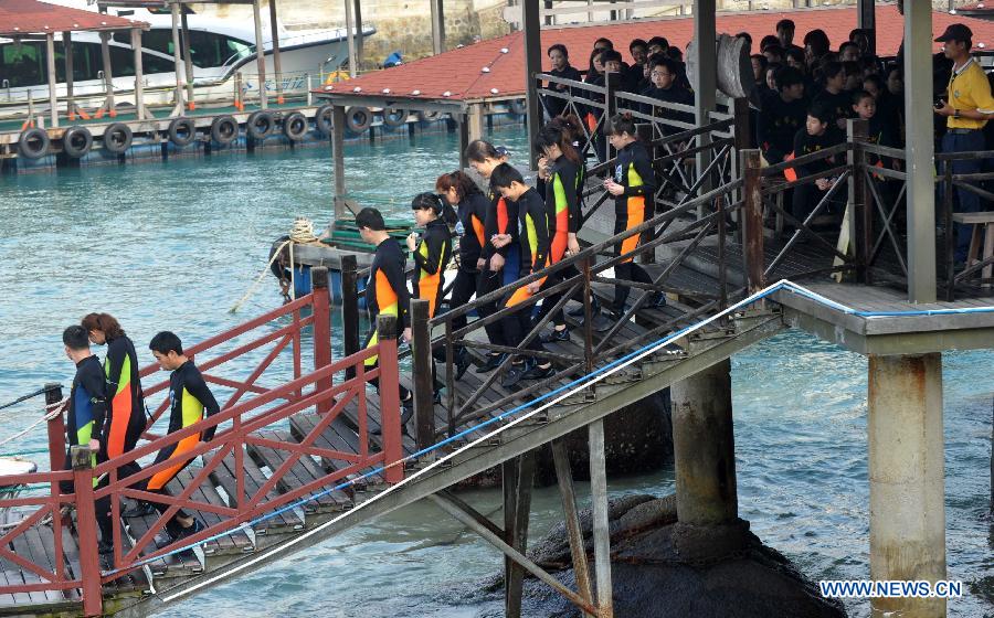 Tourists prepare to go diving at the Boundary Island scenic area in Lingshui Yi Autonomous County in south China's Hainan Province, Jan. 30, 2013. Hainan launched tourism promotion with the theme of fresh air, to attract visitors from northern China where heavy haze lingered recently. (Xinhua/Zhao Yingquan) 