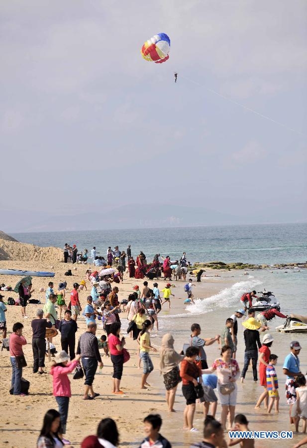 Tourists enjoy themselves at the Boundary Island scenic area in Lingshui Yi Autonomous County in south China's Hainan Province, Jan. 30, 2013. Hainan launched tourism promotion with the theme of fresh air, to attract visitors from northern China where heavy haze lingered recently. (Xinhua/Zhao Yingquan) 