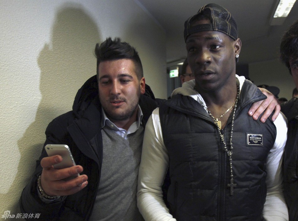 Mario Balotelli is mobbed as he arrives at the hospital for medical checks.