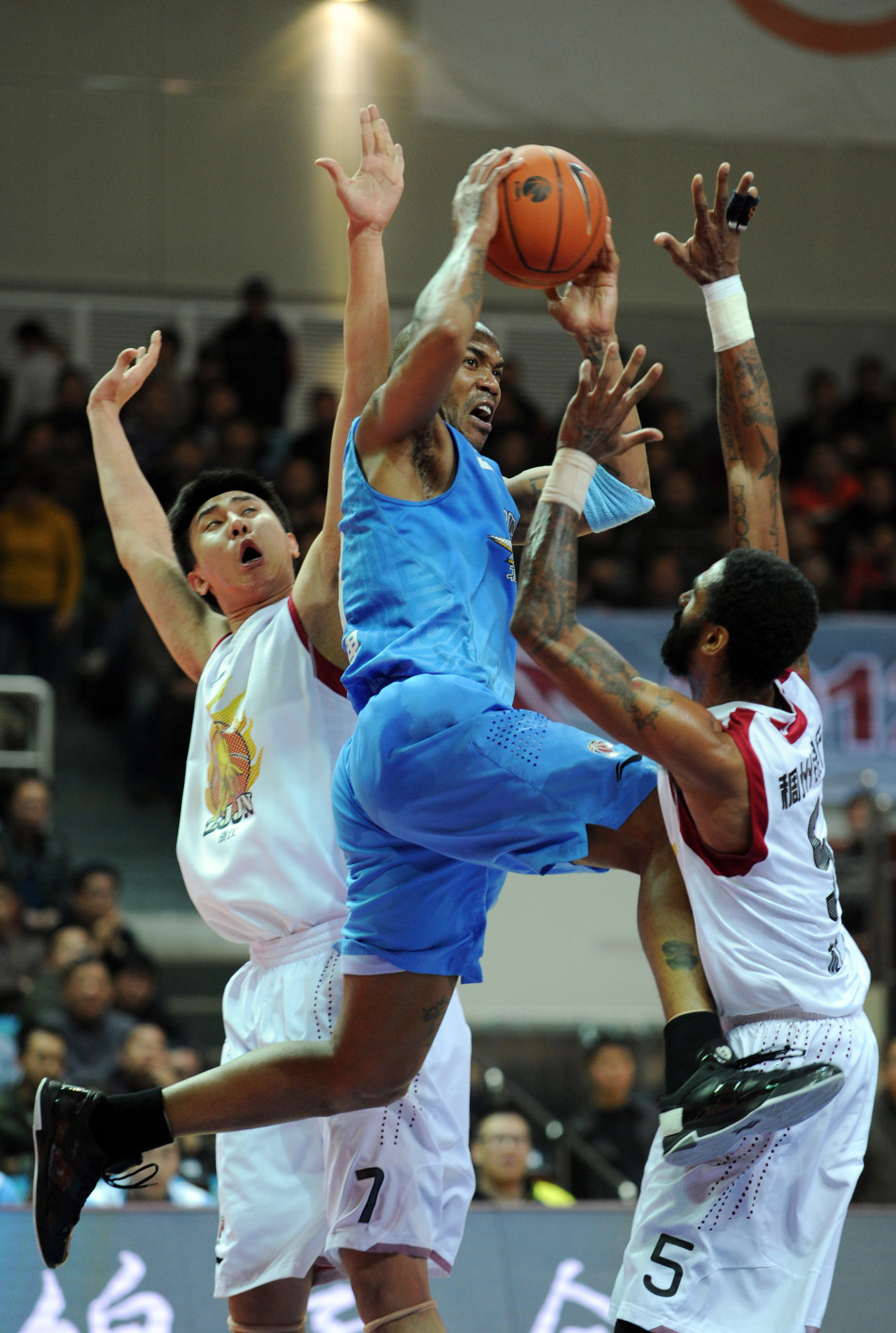 Stephon Marbury tries to pass the ball when double teamed by Zhejiang players in a CBA game between Beijing and Zhejiang on Jan.30, 2013.