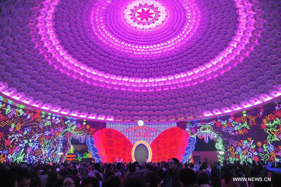 Visitors are seen under a dome decorated with lanterns on a preview of the 19th Zigong International Dinosaur Lantern Festival in Zigong, southwest China's Sichuan Province, Feb. 2, 2013.