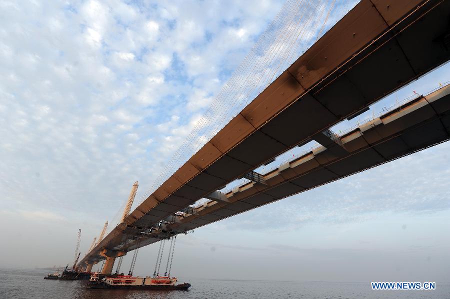 Photo taken on Feb. 3, 2013 shows boats carrying the last two steel box girders, each of which weighs 408 tons, anchor below the joint of the main span of the Jiaxing-Shaoxing Sea-Crossing Bridge in Shaoxing, east China's Zhejiang Province. 