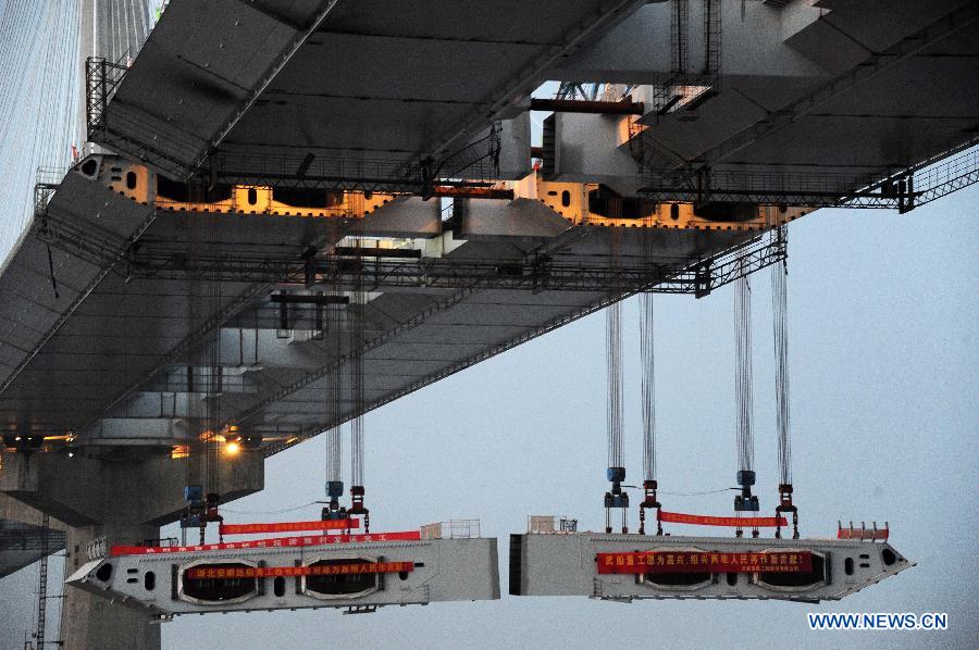 Photo taken on Feb. 3, 2013 shows the last two steel box girders, each of which weighs 408 tons, are lifted up to the floor of the Jiaxing-Shaoxing Sea-Crossing Bridge in Shaoxing, east China's Zhejiang Province. 