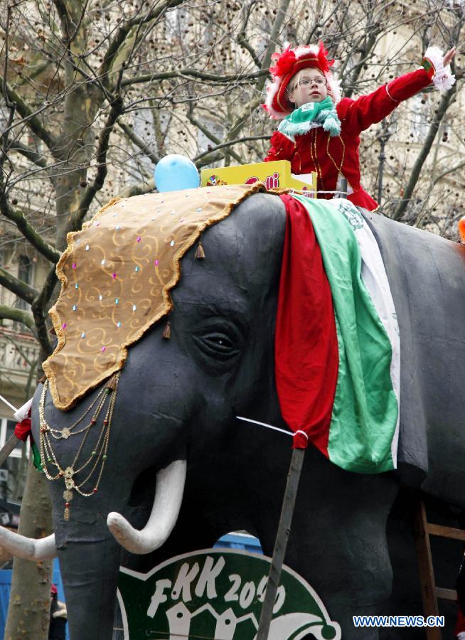 A boy throws candies and other small gifts during the grand procession of the 13th Berliner Fasching Parade in Berlin Feb. 3, 2013. 