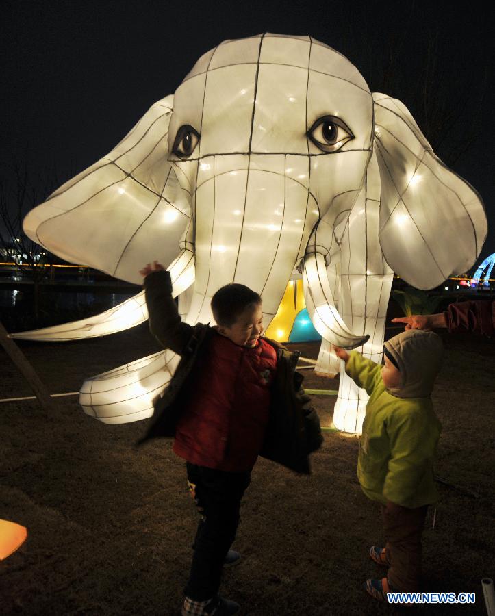 Children play in front of festive lanterns during a lantern show in Changsha, capital of central China's Hunan Province, Feb. 5, 2013.