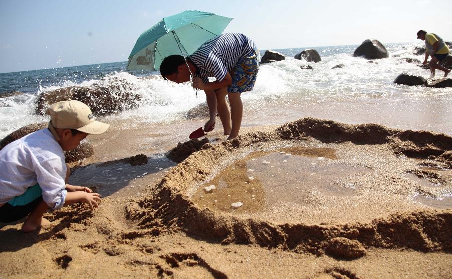 Tourists enjoy sunshine at seaside in Sanya