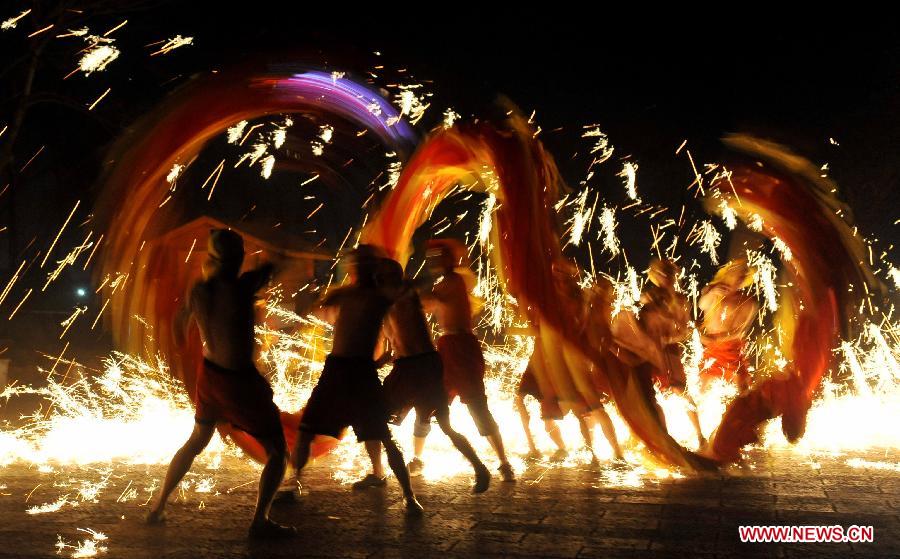 Actors perform dragon dance in firecrackers at the Daguan Park in Kunming, capital of southwest China's Yunnan Province, Feb. 6, 2013. 