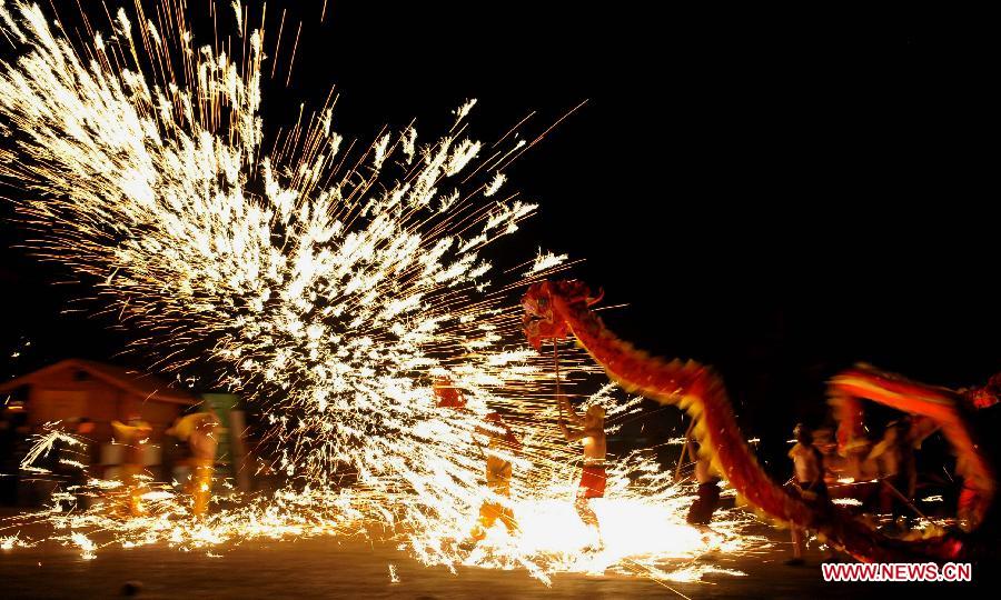 Actors perform dragon dance in firecrackers at the Daguan Park in Kunming, capital of southwest China's Yunnan Province, Feb. 6, 2013. 