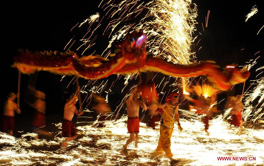 Actors perform dragon dance in firecrackers at the Daguan Park in Kunming, capital of southwest China's Yunnan Province, Feb. 6, 2013. 