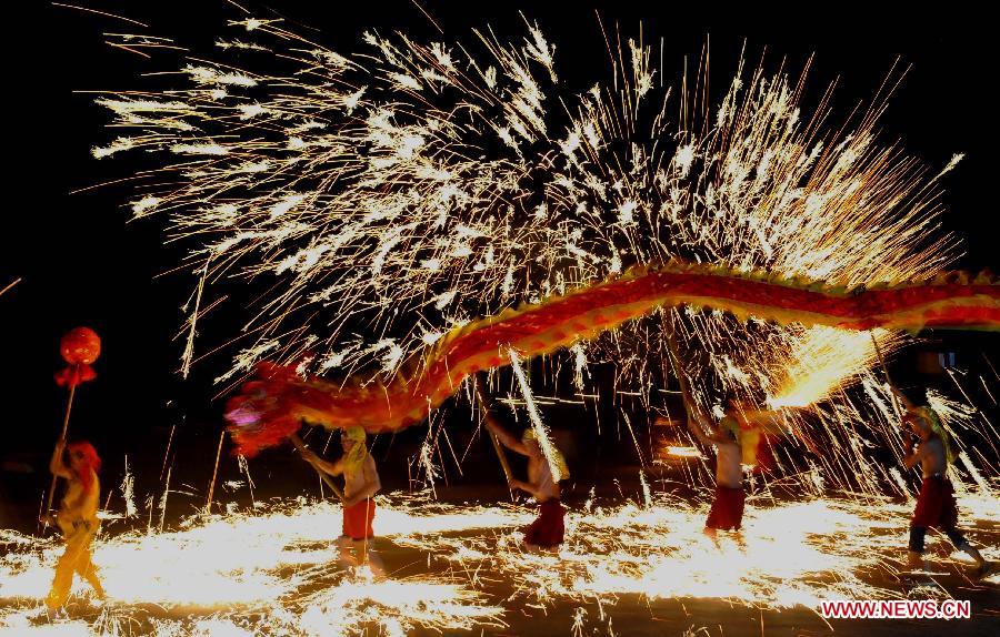 Actors perform dragon dance in firecrackers at the Daguan Park in Kunming, capital of southwest China's Yunnan Province, Feb. 6, 2013. 