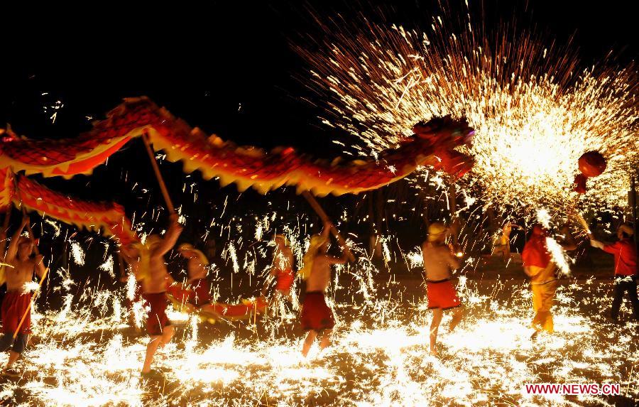 Actors perform dragon dance in firecrackers at the Daguan Park in Kunming, capital of southwest China's Yunnan Province, Feb. 6, 2013. 