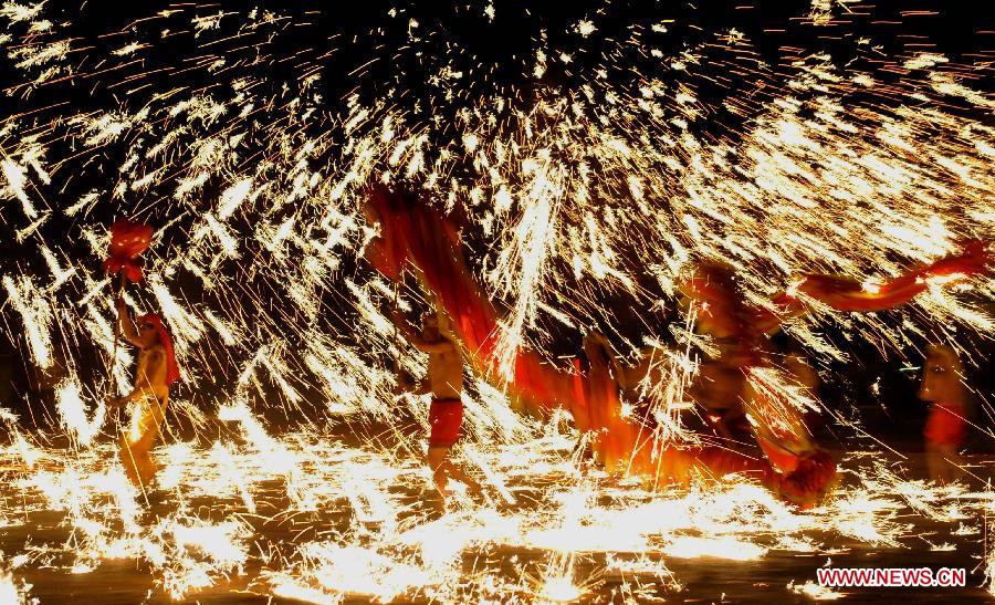 Actors perform dragon dance in firecrackers at the Daguan Park in Kunming, capital of southwest China's Yunnan Province, Feb. 6, 2013. 