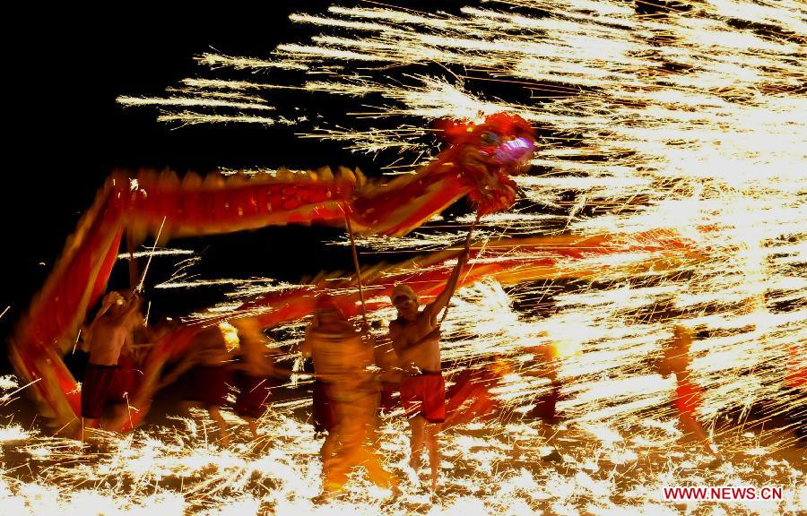 Actors perform dragon dance in firecrackers at the Daguan Park in Kunming, capital of southwest China's Yunnan Province, Feb. 6, 2013. 