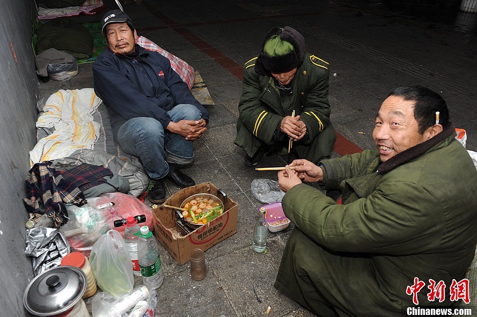 Three homeless men are enjoying hotpot under an overpass in Changsha City, Hunan Province, on February 7, 2013. Many wanderers in the city choose to celebrate the upcoming Spring Festival under overpasses. Hotpot is the only festive meal they can afford.