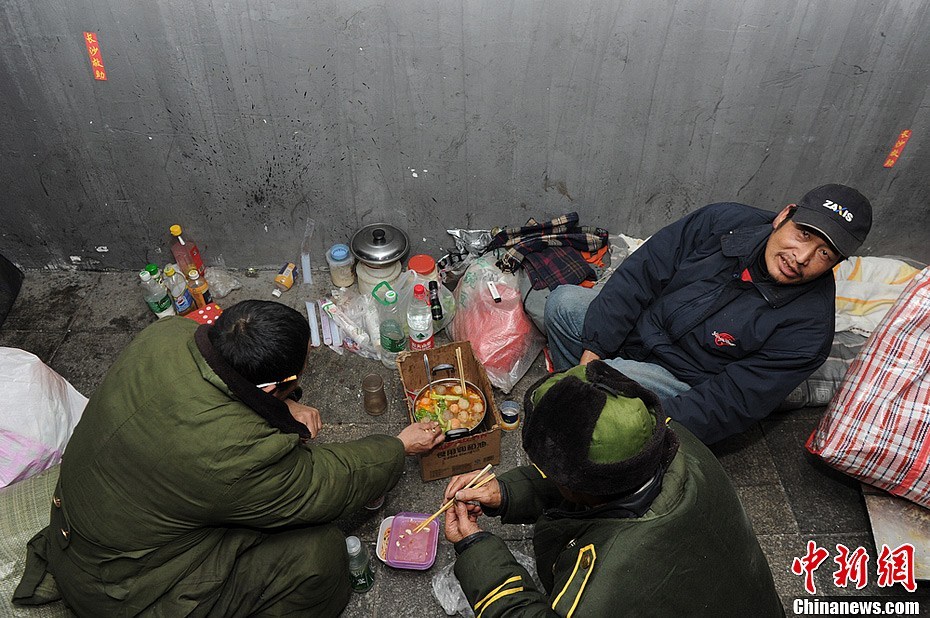 Three homeless men are enjoying hotpot under an overpass in Changsha City, Hunan Province, on February 7, 2013. Many wanderers in the city choose to celebrate the upcoming Spring Festival under overpasses. Hotpot is the only festive meal they can afford.