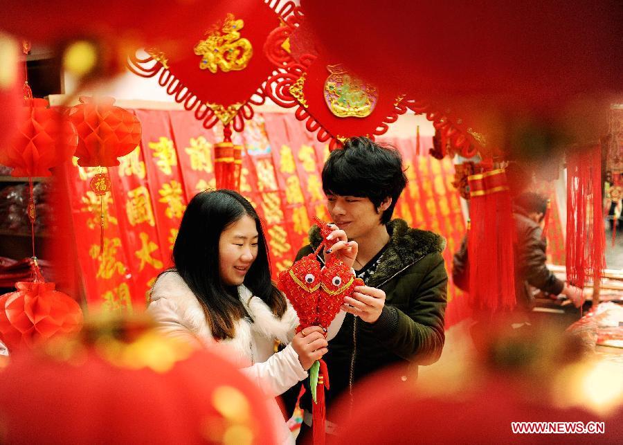 A couple select ornaments for the coming Spring Festival in Sizhou Town of Dexing City, east China's Jiangxi Province, Feb. 8, 2013. The Spring Festival, the most important occasion for the family reunion for the Chinese people, falls on the first day of the first month of the traditional Chinese lunar calendar, or Feb. 10 this year. [Xinhua]