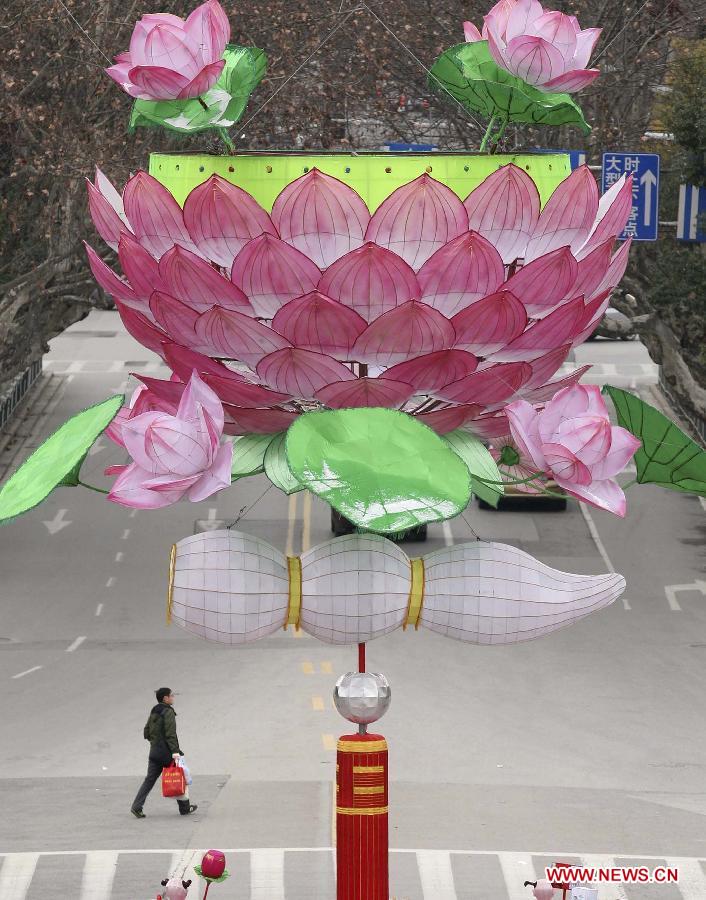 A man walks under a giant lotus lantern in Nanjing, capital of east China's Jiangsu Province, Feb. 8, 2013. The Spring Festival, the most important occasion for the family reunion for the Chinese people, falls on the first day of the first month of the traditional Chinese lunar calendar, or Feb. 10 this year. [Xinhua]