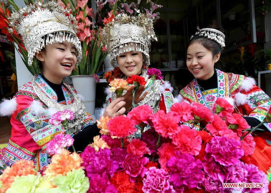 Young ladies of the Miao ethnic group select flowers for the coming Spring Festival in Rongshui County, south China's Guangxi Zhuang Autonomous Region, Feb. 8, 2013. The Spring Festival, the most important occasion for the family reunion for the Chinese people, falls on the first day of the first month of the traditional Chinese lunar calendar, or Feb. 10 this year. [Xinhua]