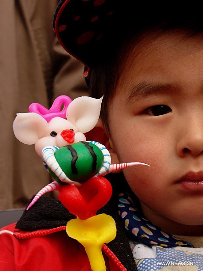 File photo taken on Feb. 21, 2007 shows a boy holding a dough figurine of pig in a temple fair in Zhengzhou, capital of central China's Henan Province. 2007 was the Year of the Pig in the Chinese Zodiac. Chinese Zodiac is represented by 12 animals to record the years and reflect people's attributes, including the rat, ox, tiger, rabbit, dragon, snake, horse, sheep, monkey, rooster, dog and pig. [Xinhua/Wang Song]