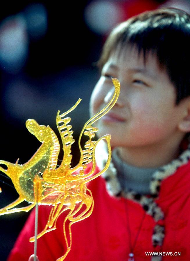 File photo taken on Feb. 17, 2002 shows a boy holding a horse-shaped candy in a temple fair in Zhengzhou, capital of central China's Henan Province. 2002 was the Year of the Horse in the Chinese Zodiac. Chinese Zodiac is represented by 12 animals to record the years and reflect people's attributes, including the rat, ox, tiger, rabbit, dragon, snake, horse, sheep, monkey, rooster, dog and pig.[Xinhua/Wang Song]