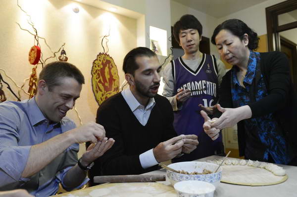 Former NBA star Stojakovic (C) learns how to make dumplings at a Chinese Fan's home on Feb 7, 2013. [q.sohu.com]