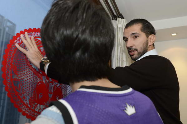 Former NBA star Peja Stojakovic puts on a paper-cutting on windows with his Chinese fan on Feb 7, one day before the Chinese New Year's Eve. [q.sohu.com] 