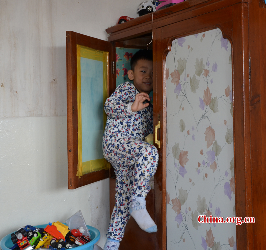  Sneaking in and out of the wardrobe in his grandpa's 15-square-meters house is Gao Yubo's favorite game. [By Gong Yingchun/China.org.cn]