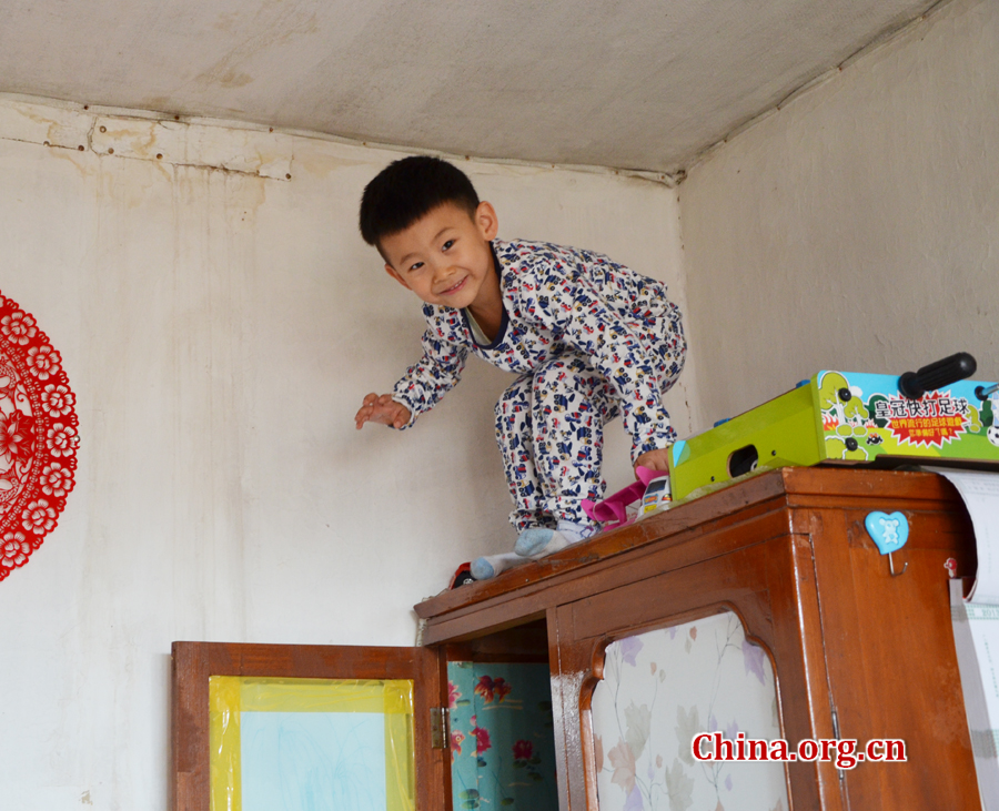  Sneaking in and out of the wardrobe in his grandpa's 15-square-meters house is Gao Yubo's favorite game. [By Gong Yingchun/China.org.cn]