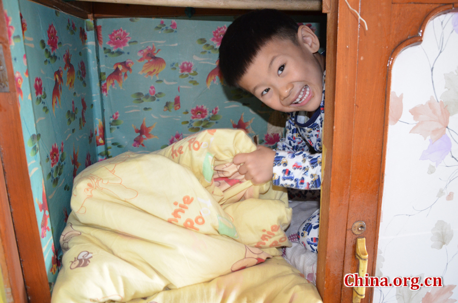  Sneaking in and out of the wardrobe in his grandpa's 15-square-meters house is Gao Yubo's favorite game. [By Gong Yingchun/China.org.cn]