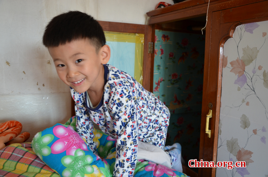  Sneaking in and out of the wardrobe in his grandpa's 15-square-meters house is Gao Yubo's favorite game. [By Gong Yingchun/China.org.cn]