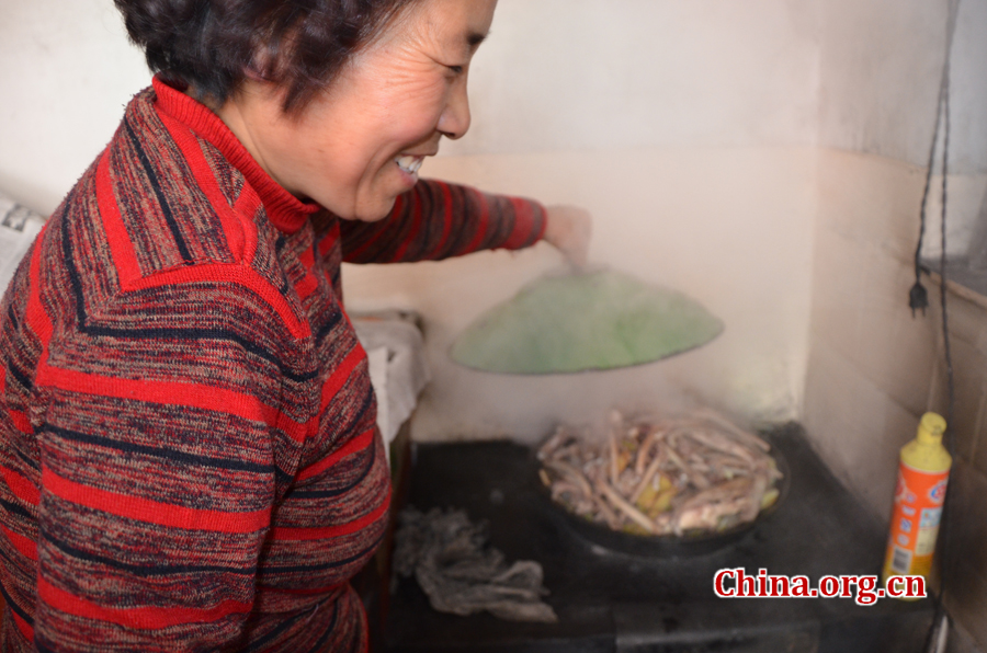 Gao Yubo's Grandma is cooking dishes for the Chinese New Year's Eve [By Gong Yingchun/China.org.cn] 