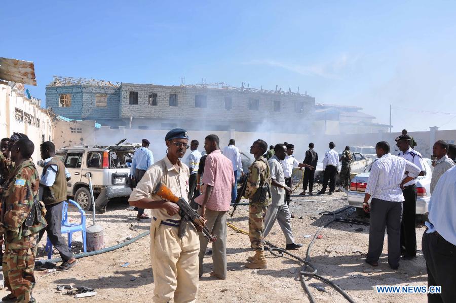 Somali government soldiers gather at the scene of car bomb blast that targeted a popular beachfront restaurant in Mogadishu, Somalia, Feb. 16, 2013. 