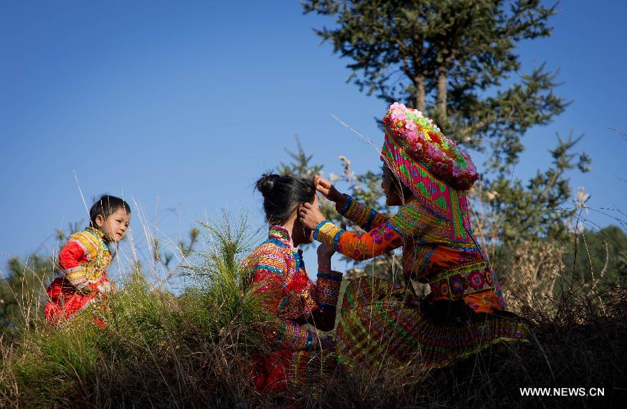 Zhang Lu (C), a bride of the Lisu ethnic group, has her face shaven before her wedding in Xinyu Village of Dechang County, southwest China's Sichuan Province, Feb. 15, 2013.