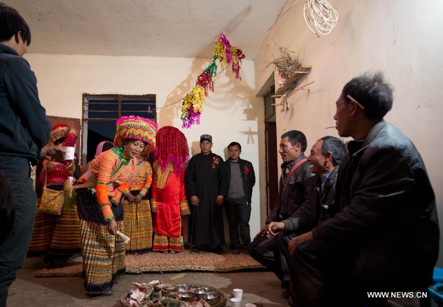 Family members of a Lisu wedding couple attend a bow ceremony which officially makes the couple husband and wife in Xinyu Village of Dechang County, southwest China's Sichuan Province, Feb. 15, 2013