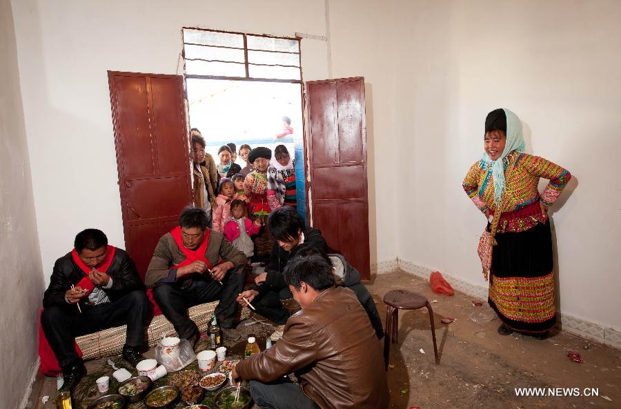 Hosts and witnesses of a traditional Lisu wedding have meal at the bride's home in Xinyu Village of Dechang County, southwest China's Sichuan Province, Feb. 15, 2013