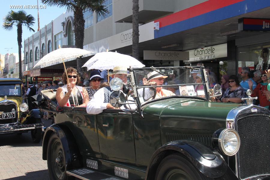 People drive a vintage car in the Vintage Car Parade in Napier, New Zealand, Feb. 16, 2013