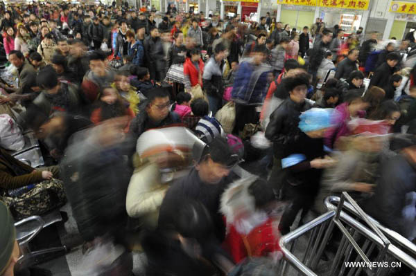 Passengers enter Guiyang Railway Station in Guiyang, capital of southwest China's Guizhou Province, Feb. 15, 2013. 
