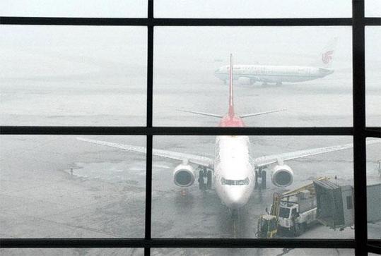 Airplanes wait in fog at the Beijing Capital International Airport in Beijing, capital of China, Feb. 17, 2013. [Xinhua]