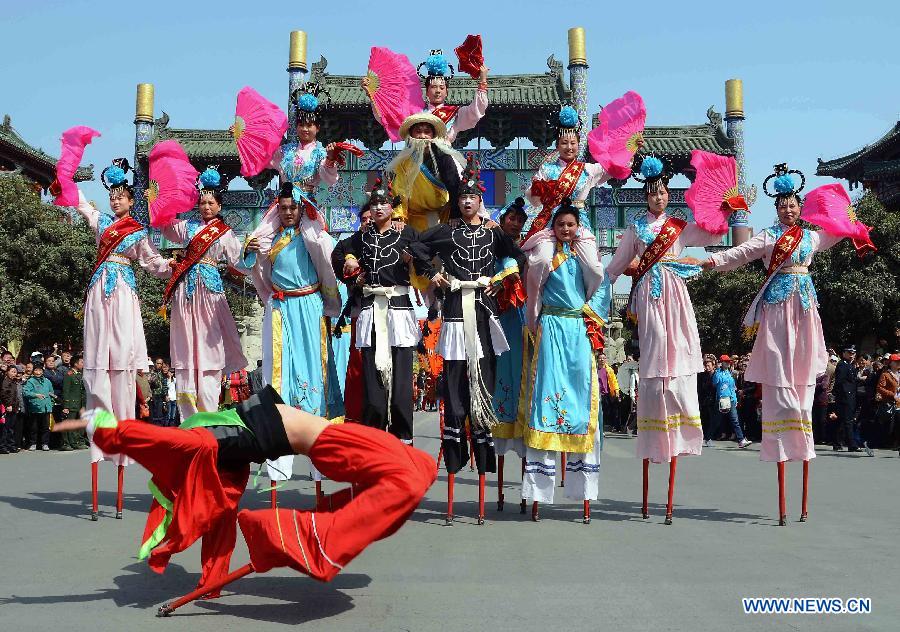 File photo taken on April 1, 2012 shows Shehuo performers stage a stilt show during a Qingming Festival parade in Kaifeng, central China's Henan Province.