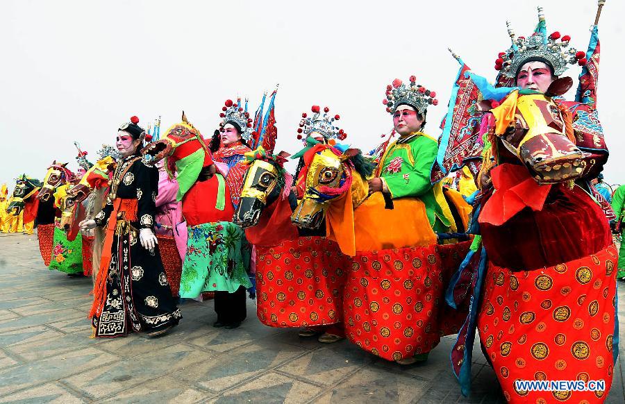 File photo taken on April 1, 2012 shows Shehuo performers stage a stilt show during a Qingming Festival parade in Kaifeng, central China's Henan Province.