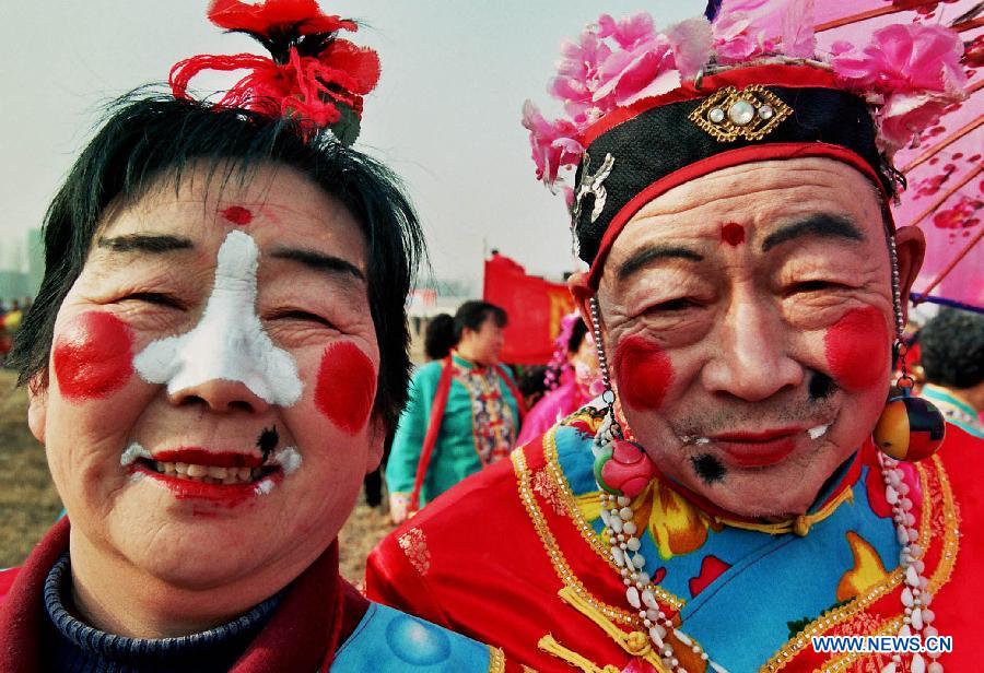 File photo taken on Feb. 11, 2006 shows a young folk artist doing facial makeup for Shehuo performances in Xidian Village of Jiuxian Town, Songxian County, central China's Henan Province. 