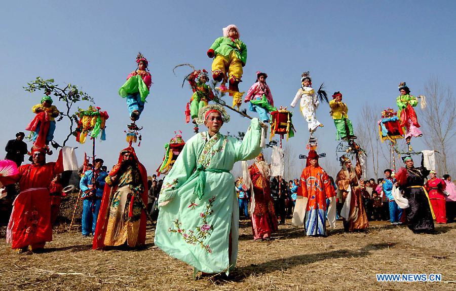 File photo taken on Feb. 11, 2006 shows a young folk artist doing facial makeup for Shehuo performances in Xidian Village of Jiuxian Town, Songxian County, central China&apos;s Henan Province. 